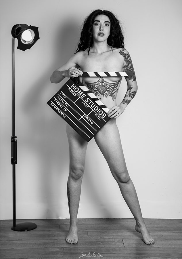 Ritratto in piedi in bianco e nero con un ciak cinematografico