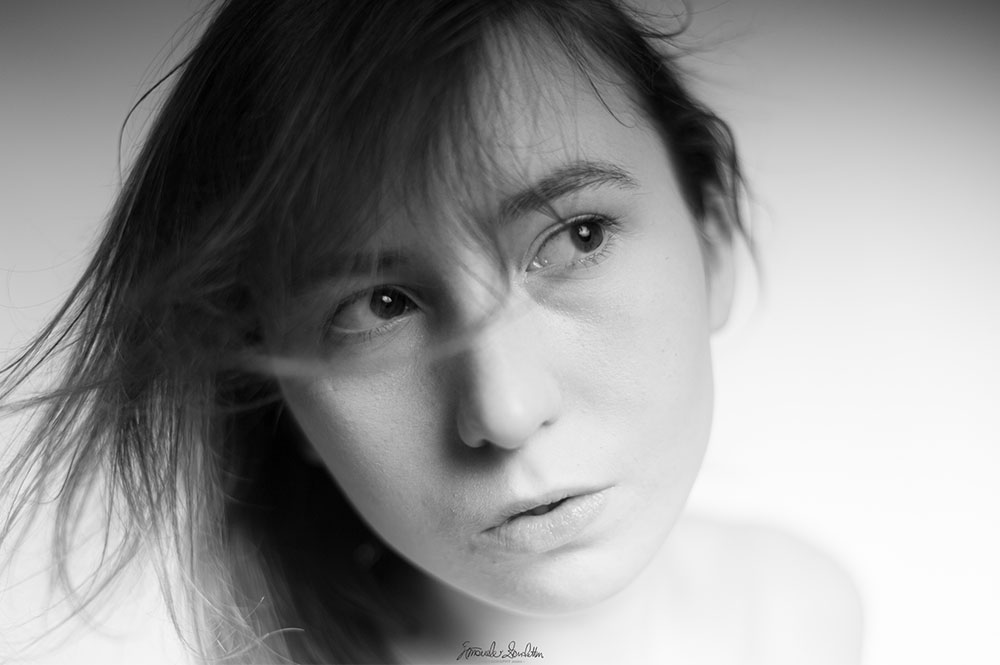 Ritratto ravvicinato high-key in bianco e nero con capelli mossi dal vento