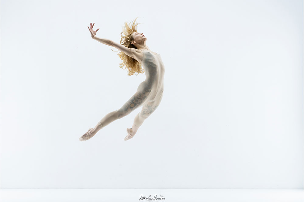 Ritratto high-key di una ballerina colta durante un salto