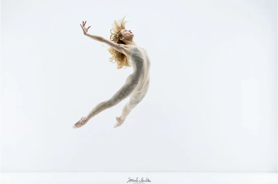 Ritratto high-key di una ballerina colta durante un salto