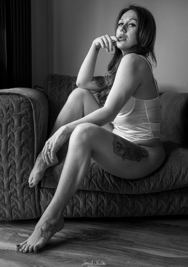 Black-and-white seated portrait on a patterned sofa