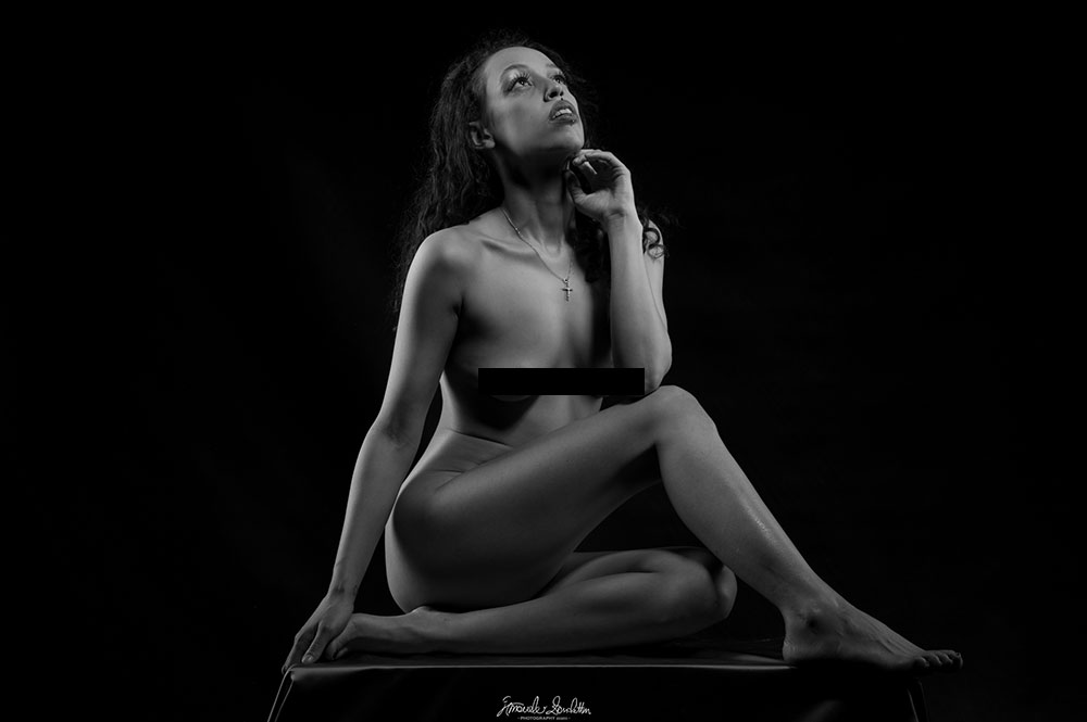 Low-key black-and-white seated figure looking upward